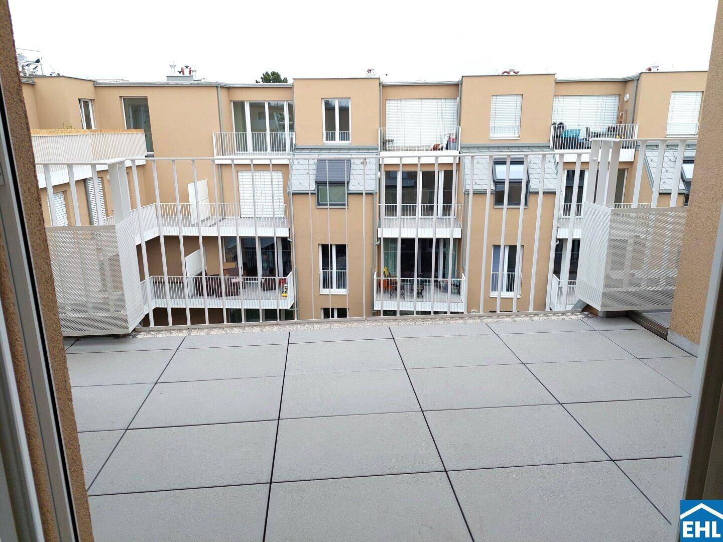 Geräumige Terrasse mit Blick auf die umliegenden Wohngebäude und Balkone.