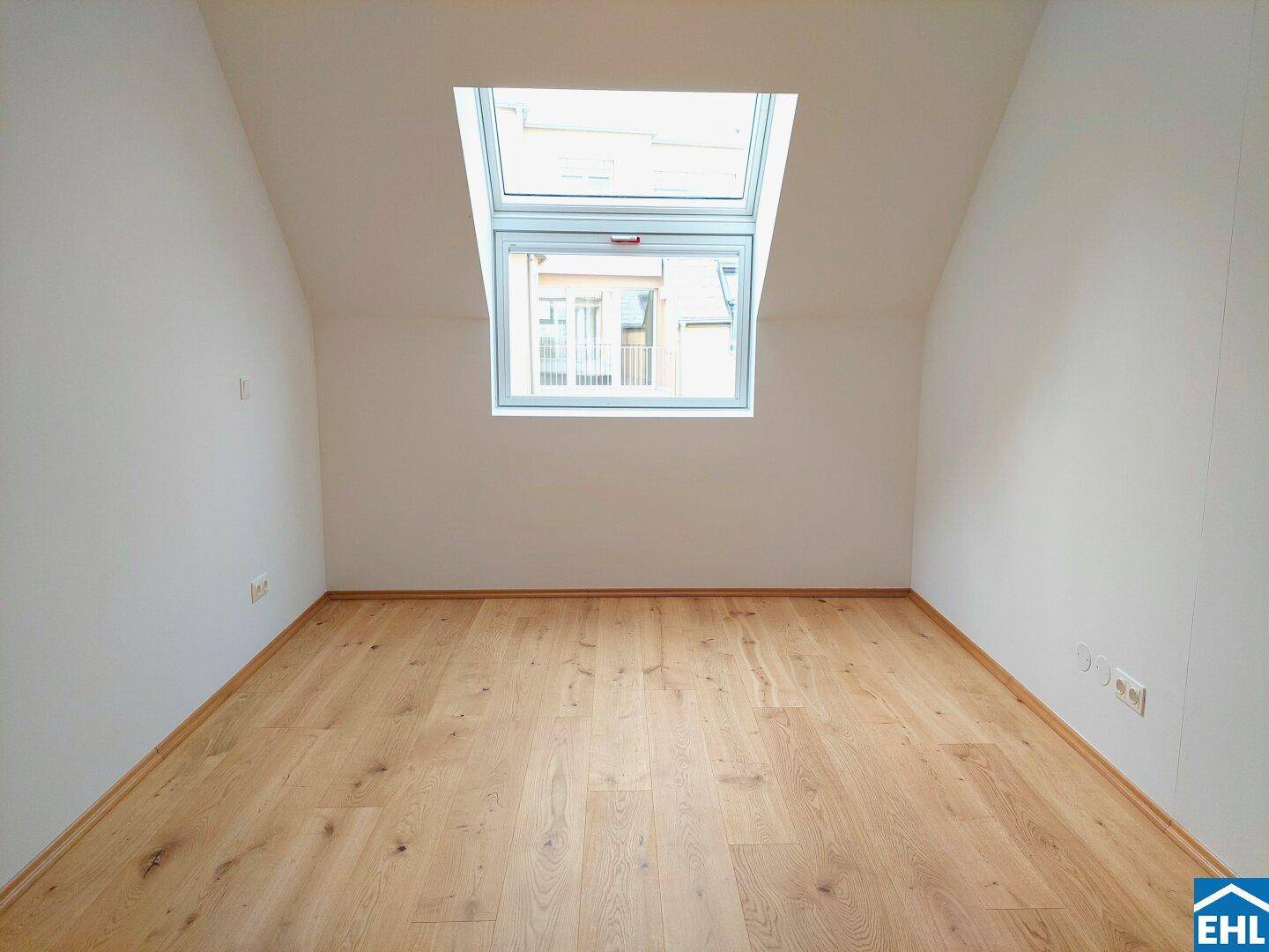 Helles Zimmer im Dachgeschoss mit Holzboden und großem Dachfenster, ideal für individuelle Nutzung.