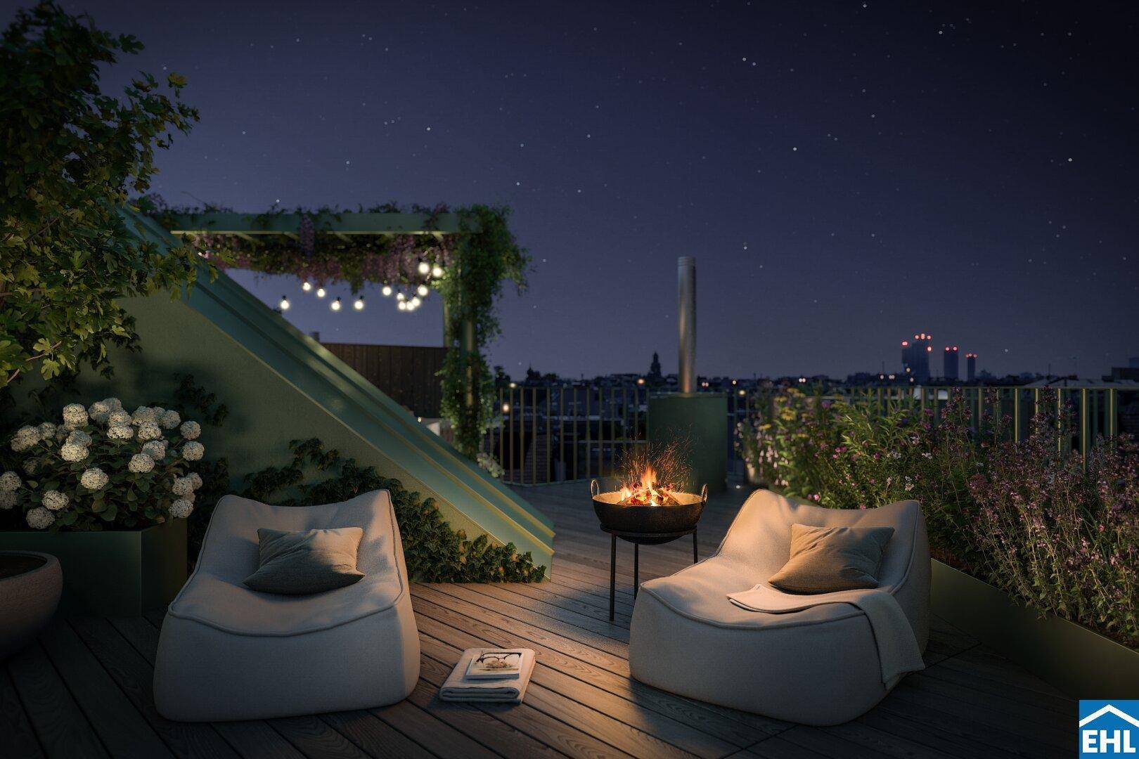 Stimmungsvolle Dachterrasse bei Nacht mit Feuerstelle und gemütlichen Sitzsäcken.