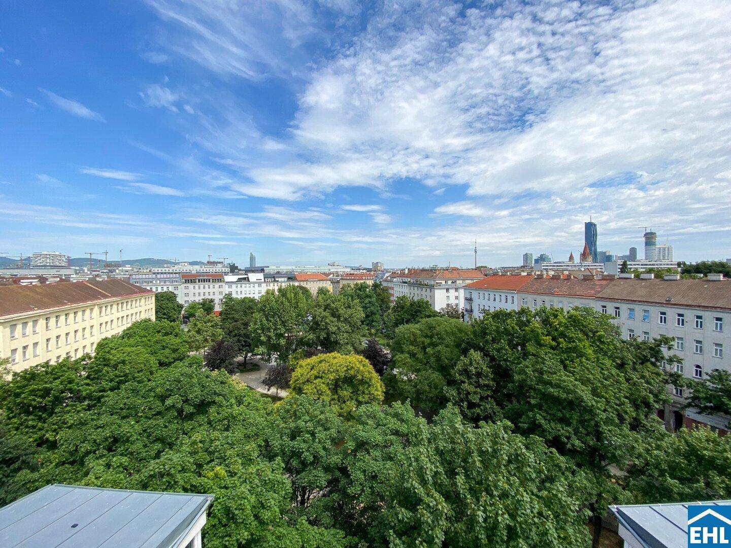 Panoramablick über eine grüne Parkanlage und die umliegenden Stadtgebäude.
