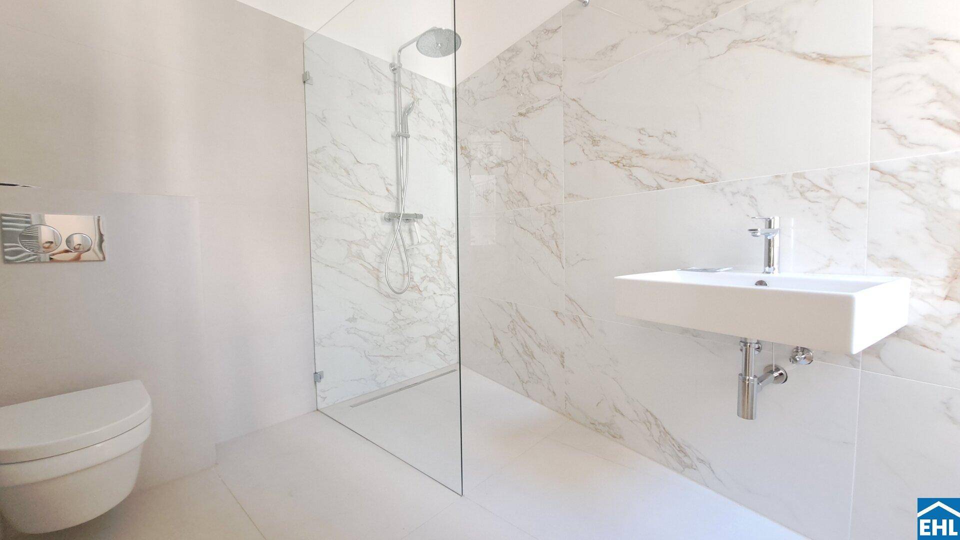 Modernes Badezimmer mit begehbarer Dusche, Wand-WC und eleganten Marmorfliesen.