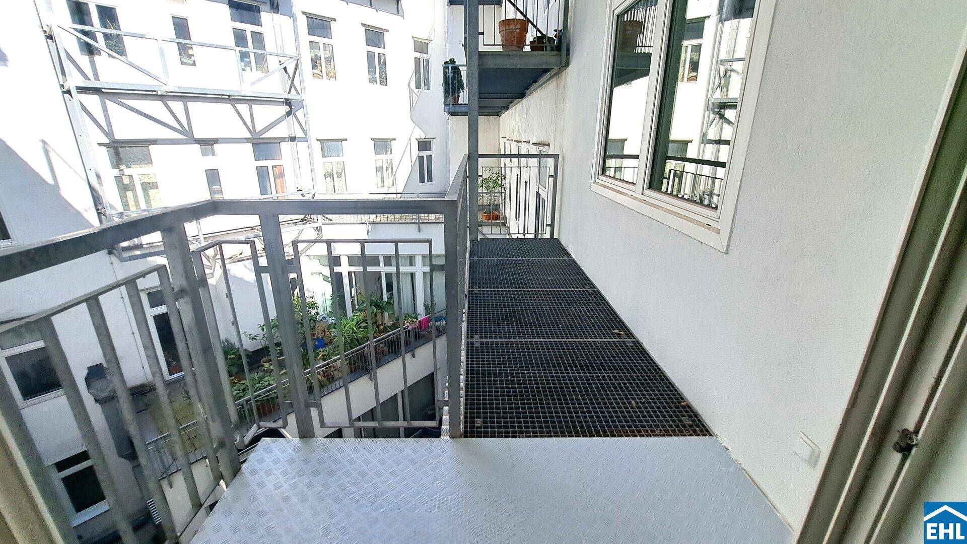 Metallbalkon mit Gitterboden und Blick auf den Innenhof, ideal für entspannte Stunden im Freien.