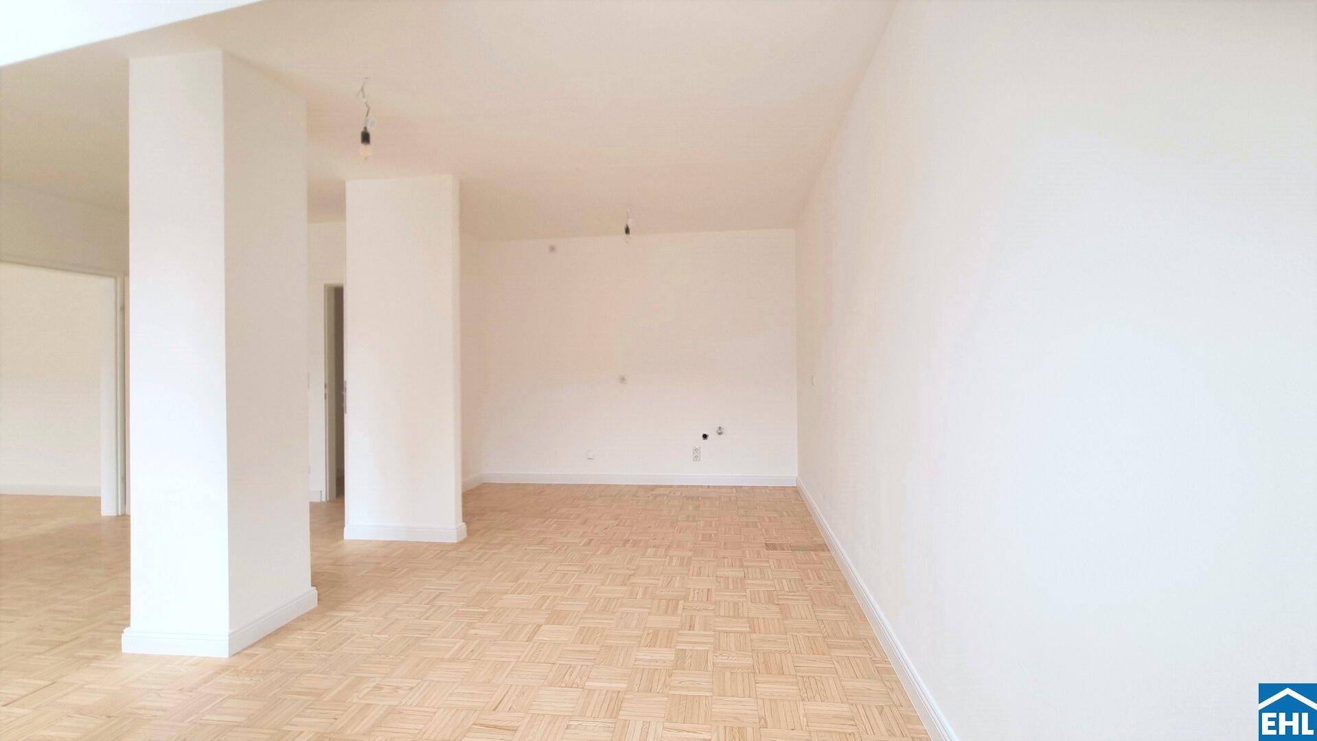 Geräumiger, offener Wohnbereich mit hellem Parkettboden und weißen Säulen, ideal für individuelle Gestaltung.