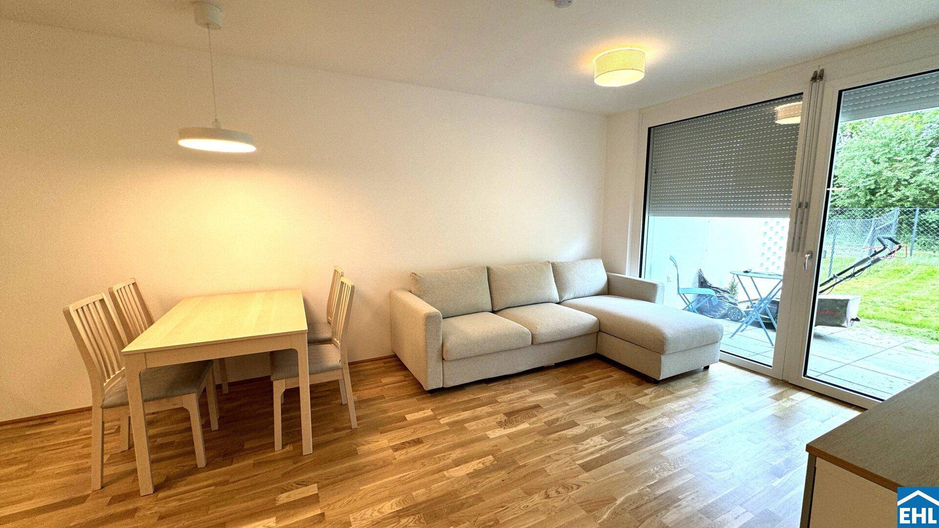 Gemütlicher Wohnbereich mit Sofa, Esstisch und Zugang zur Terrasse.