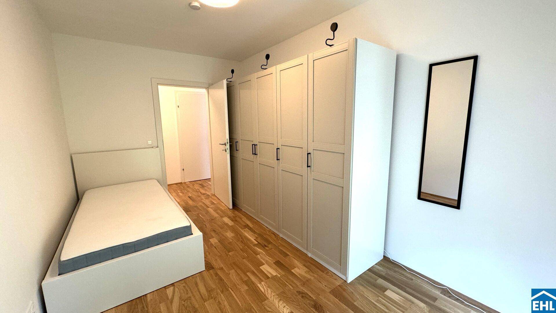 Schlafzimmer mit Holzboden, Kleiderschrank und Einzelbett.