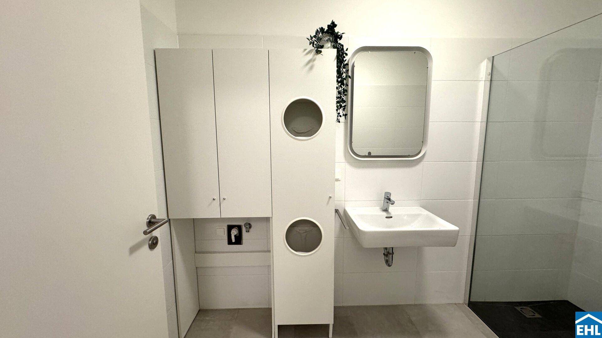 Modernes Badezimmer mit Waschbecken, Spiegelschrank und weißen Fliesen.