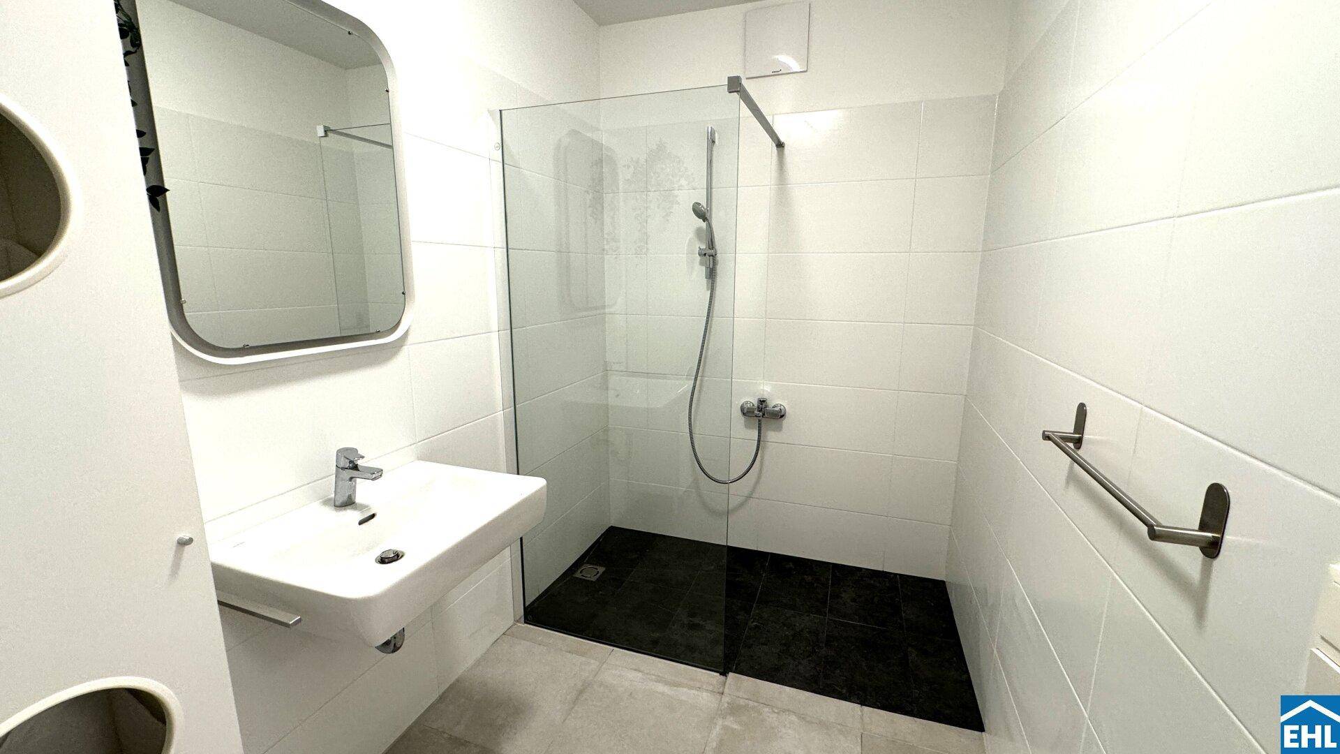 Helles Badezimmer mit ebenerdiger Dusche und modernen Fliesen.