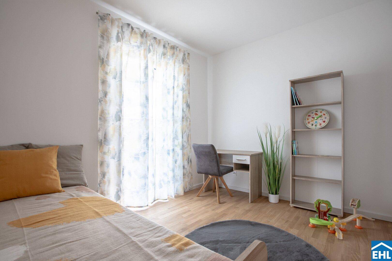 Freundliches Kinder- oder Gästezimmer mit Einzelbett, Schreibtisch und Bücherregal.