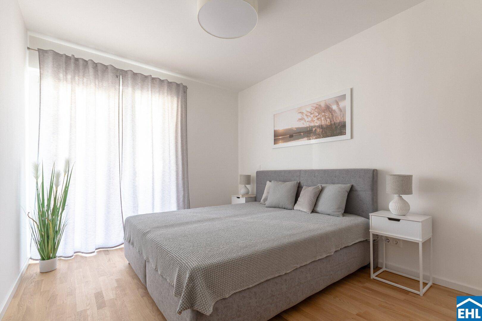 Helles Schlafzimmer mit großem Doppelbett, Nachttischen und viel natürlichem Licht durch das Fenster.