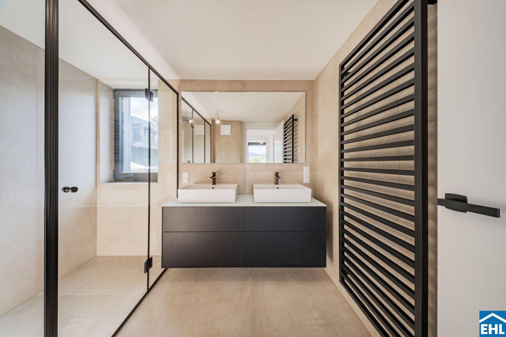 Modernes Badezimmer mit Doppelwaschbecken, begehbarer Dusche und beheiztem Handtuchhalter.