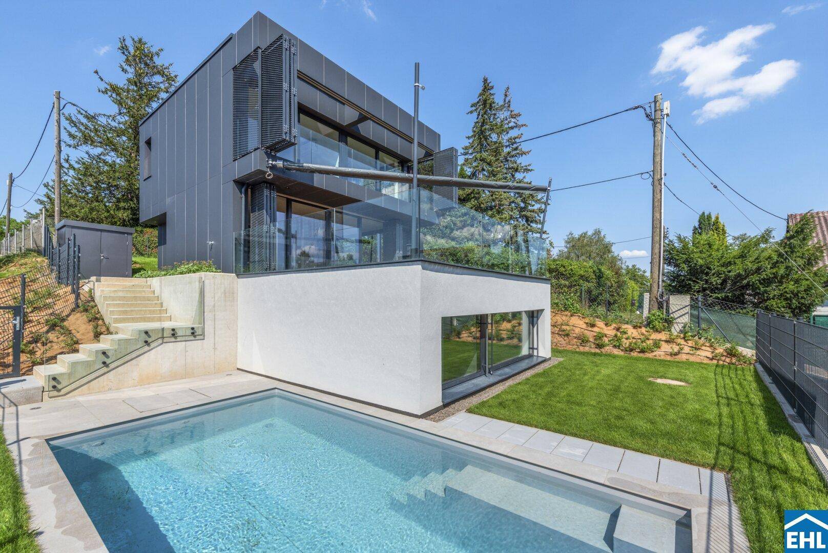Ansicht des modernen Hauses mit Poolbereich, Treppe und umliegender Natur.