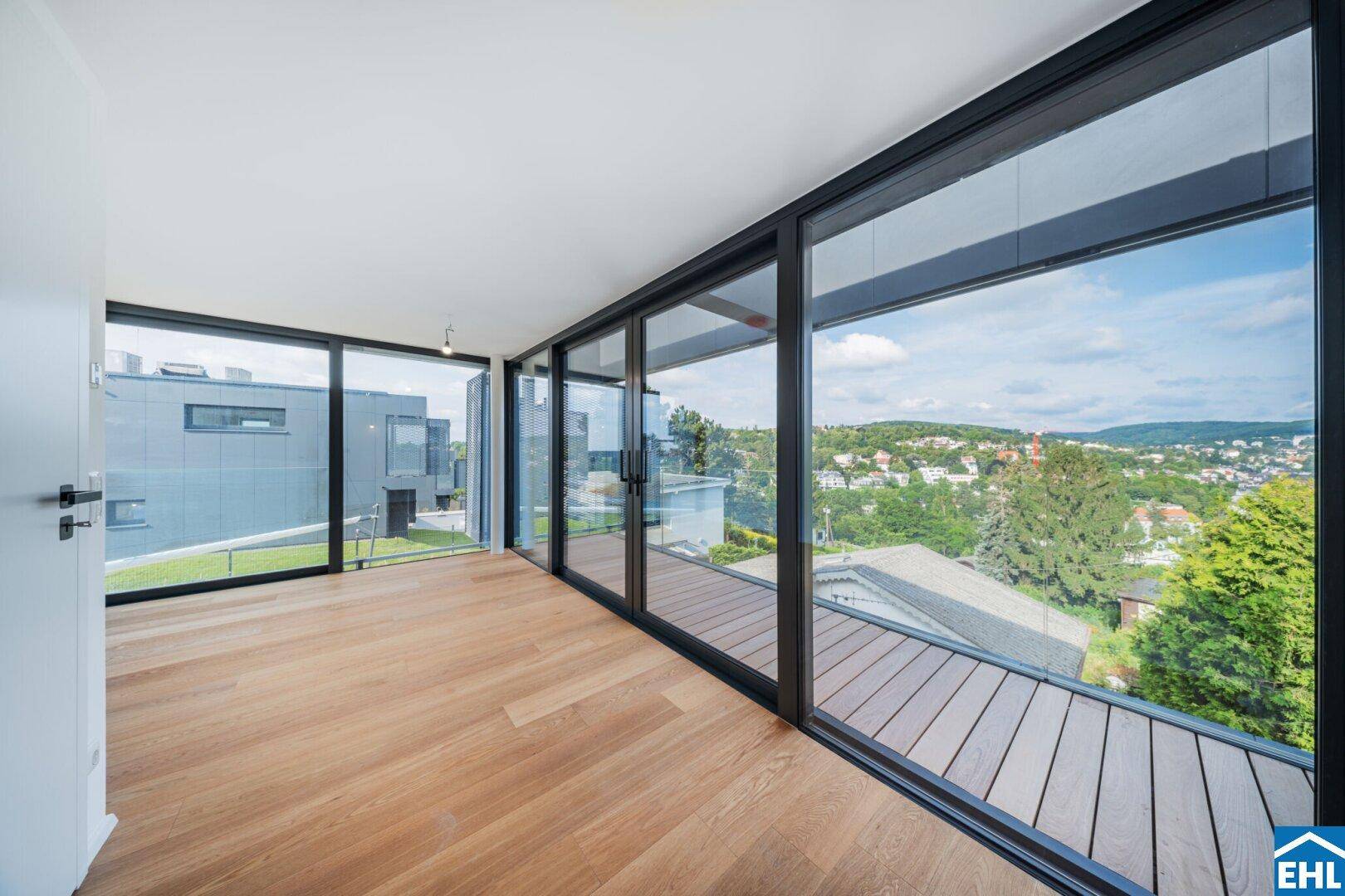 Geräumiger Wohnbereich mit durchgehenden Fensterfronten und Blick auf die Umgebung.