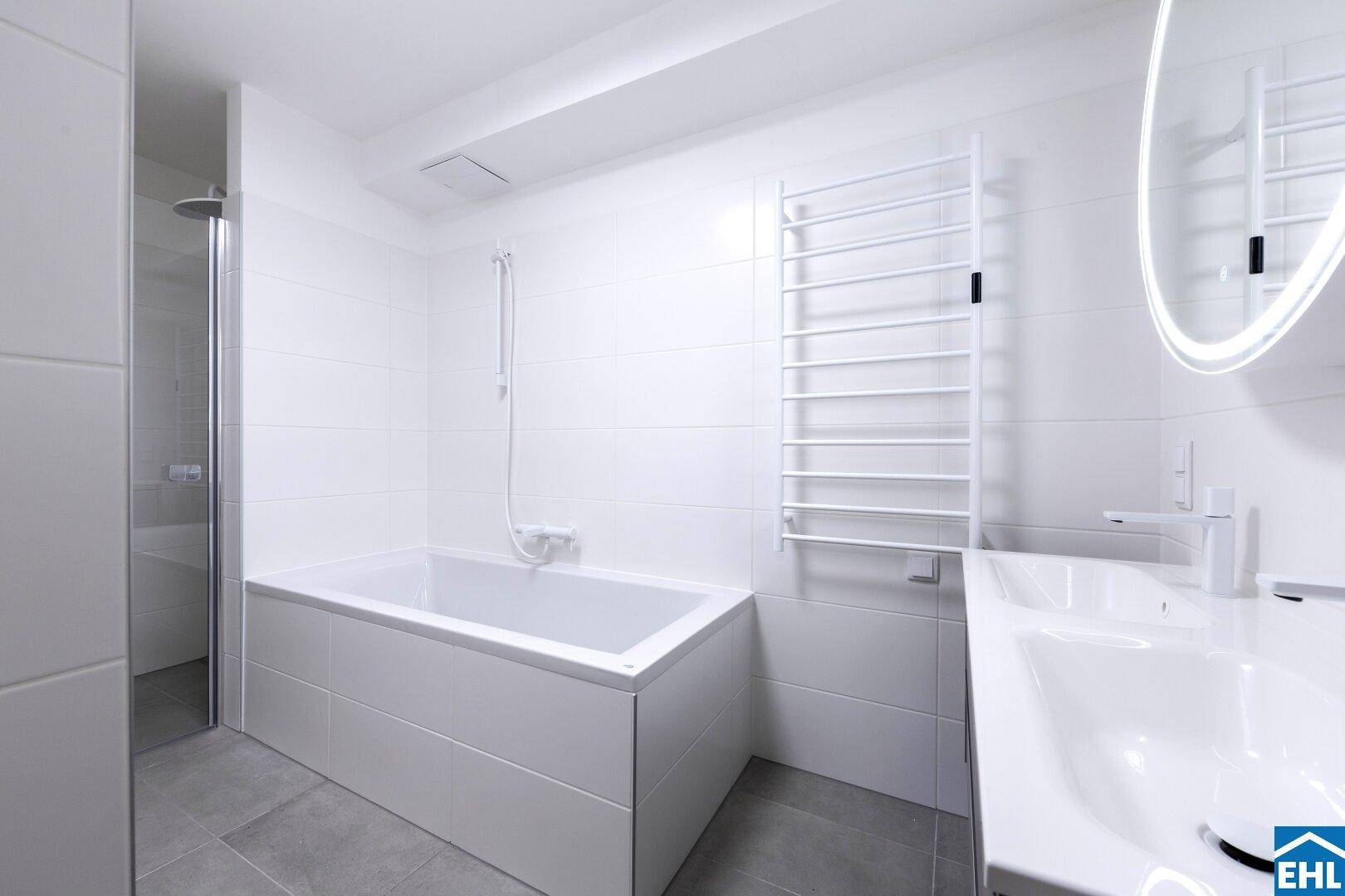 Modernes Badezimmer mit Badewanne, Dusche und beheiztem Handtuchhalter in strahlendem Weiß.