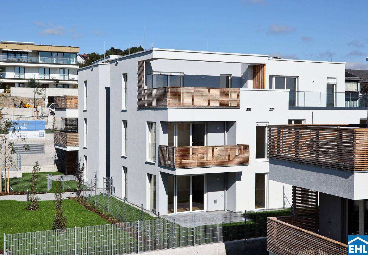 Neubau-Wohnanlage mit mehreren Etagen, modernen Balkonen und Terrassen.