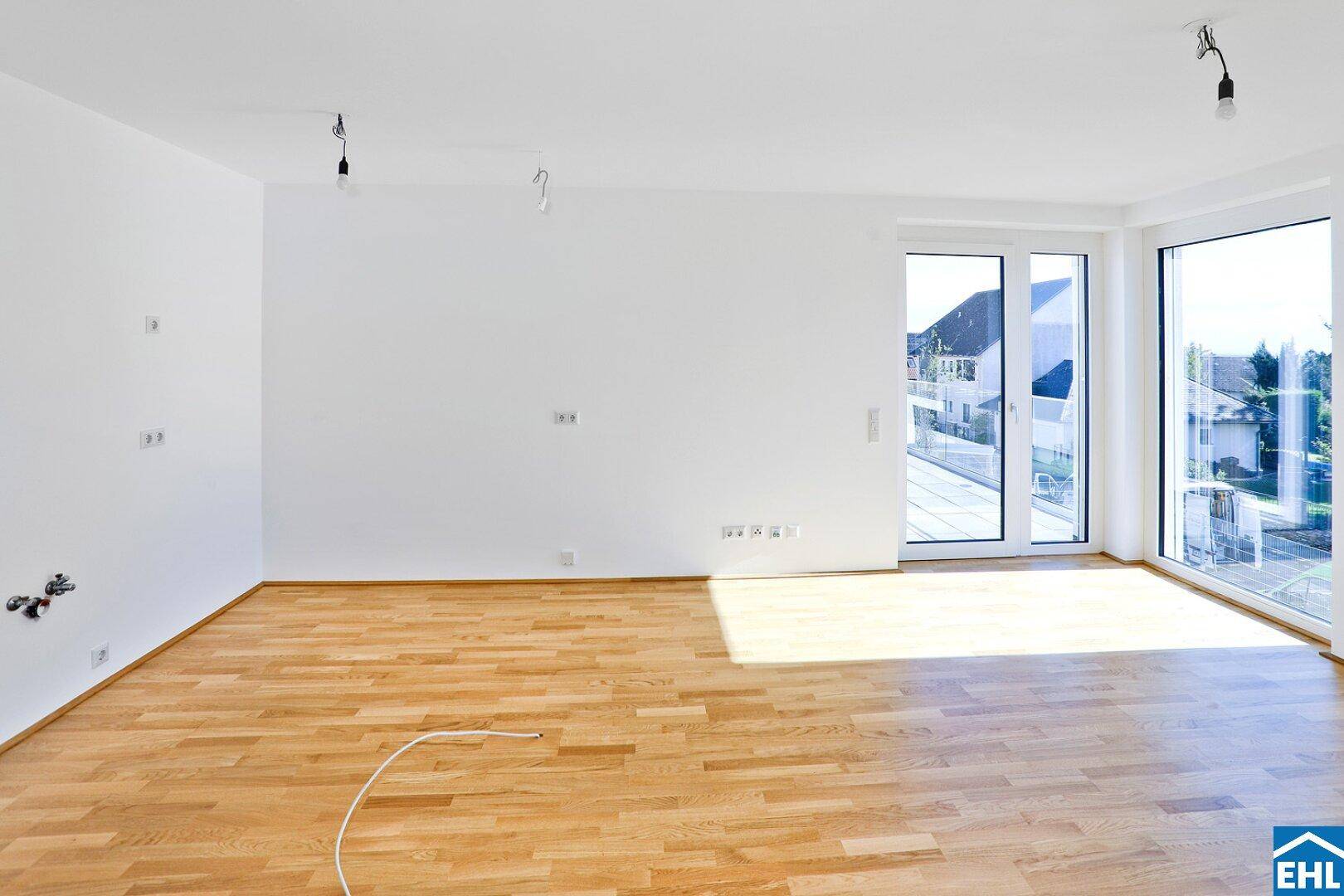 Heller Wohnbereich mit Eichenparkett und großen Fenstern, die viel Tageslicht hereinlassen.