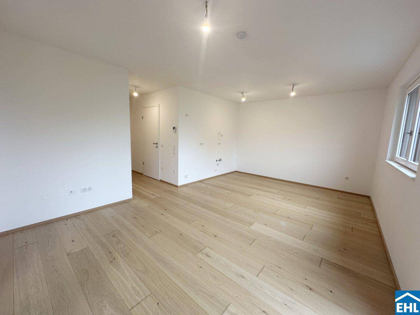 Geräumiges, leeres Zimmer mit hellem Parkettboden und weißen Wänden, bereit zum Einzug.