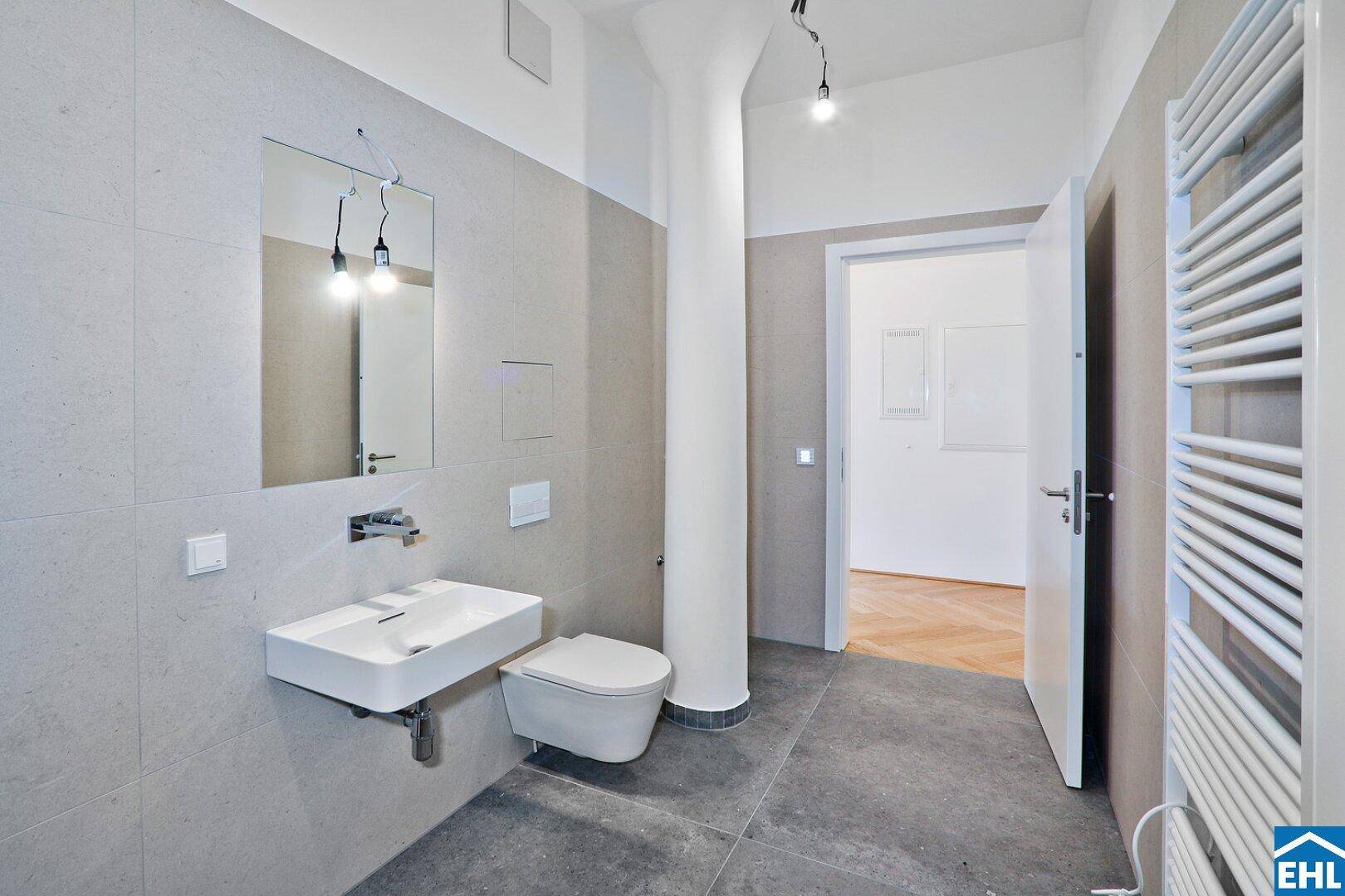Zeitgemäßes Badezimmer mit großformatigen Fliesen, Wand-WC und schwebendem Waschbecken.