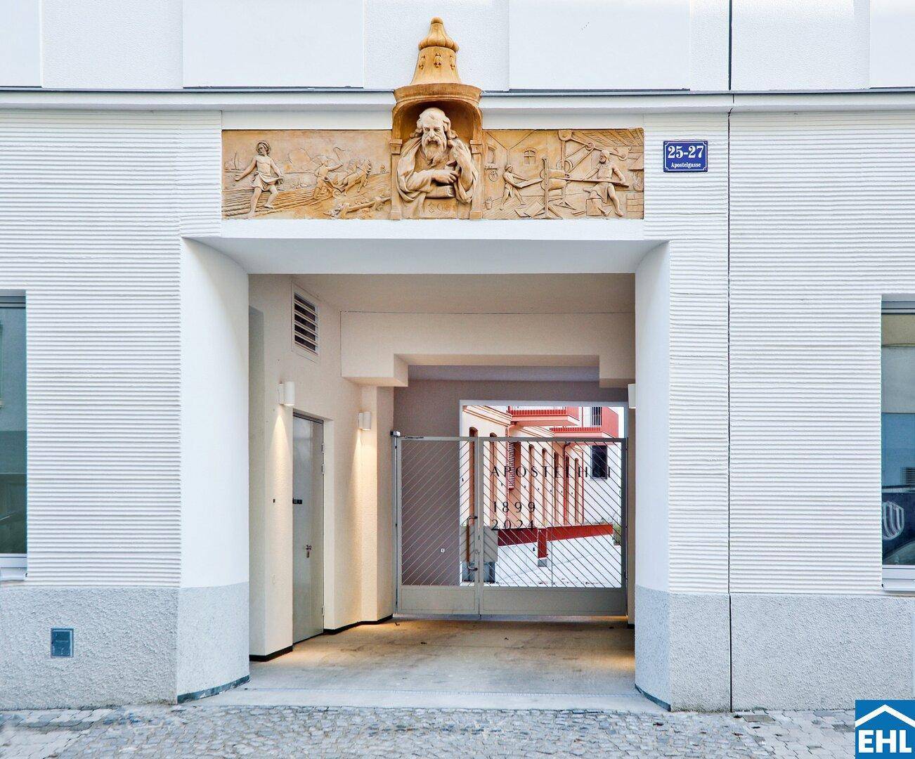 Eingangsportal mit dekorativem Relief über dem Durchgang, der zum Innenhof führt.