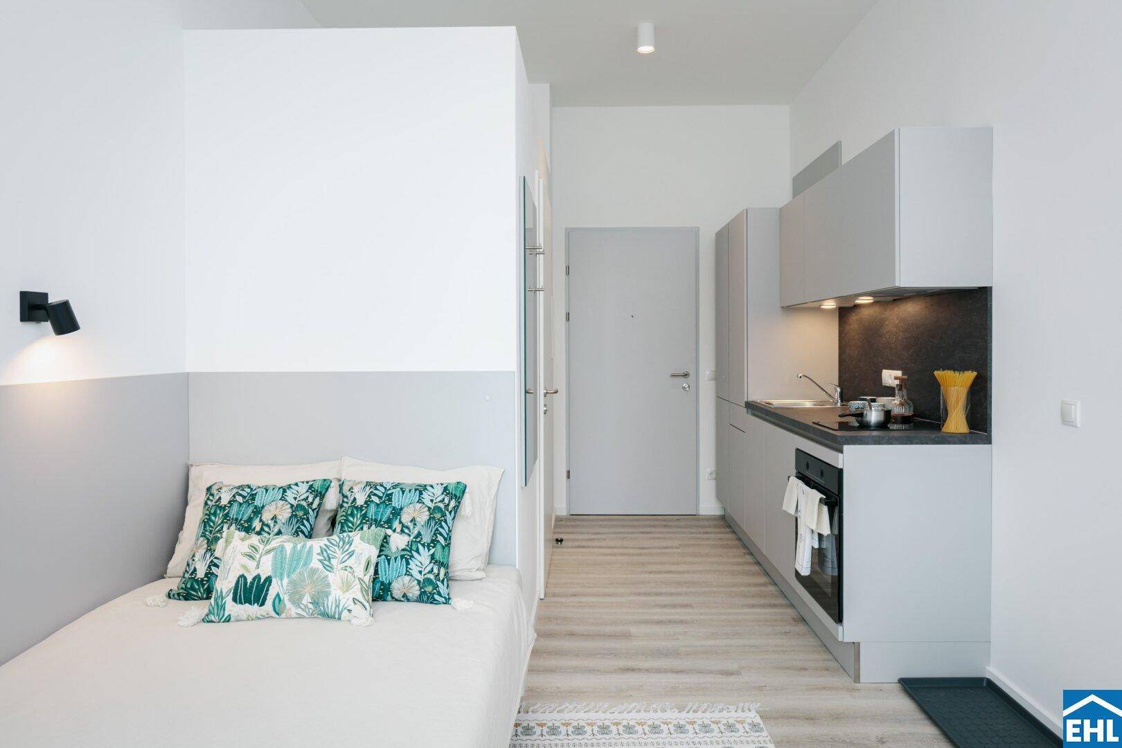 Modernes Studio-Apartment mit integrierter Küchenzeile und Schlafbereich.