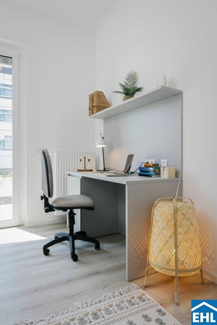 Heller Arbeitsbereich im Studio mit Schreibtisch, Regal und natürlichem Licht vom Fenster.
