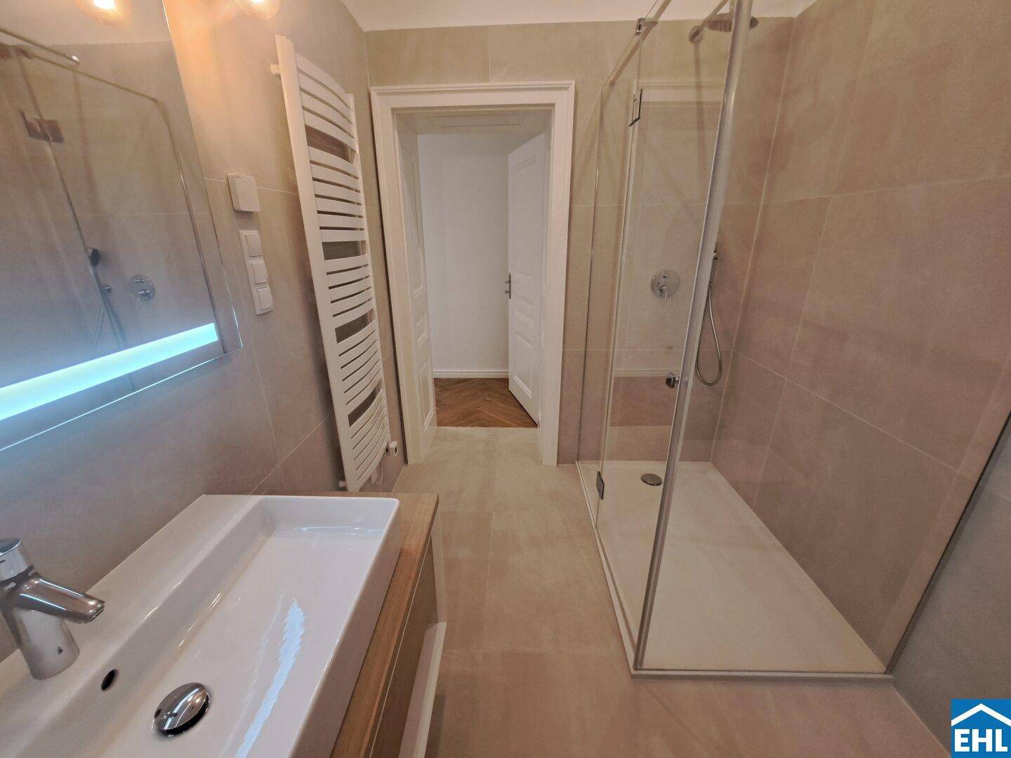 Elegantes Badezimmer mit großzügiger begehbarer Dusche und modernem Waschtisch.