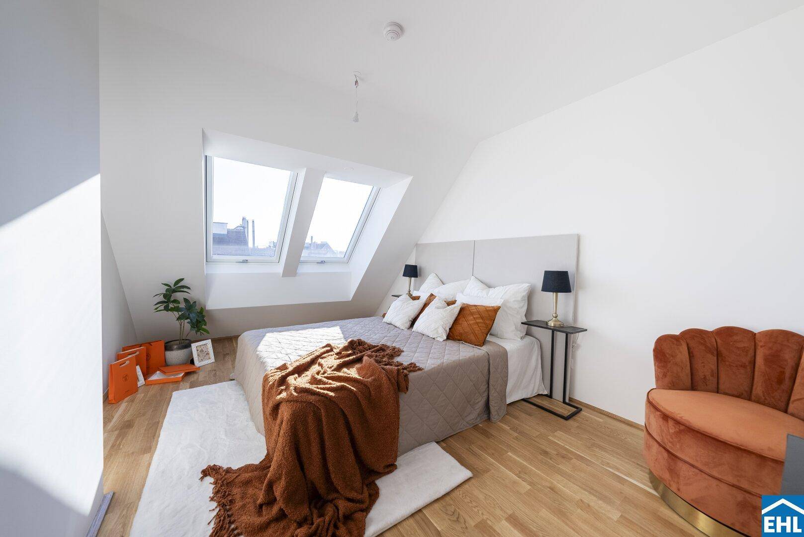 Gemütliches Schlafzimmer mit Holzboden, Dachschrägen und viel natürlichem Licht.