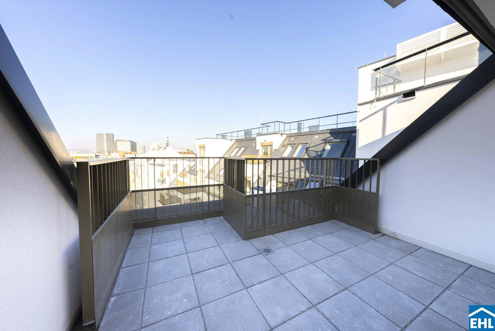 Geräumige Dachterrasse mit Fliesenboden und weitem Blick über die Stadtlandschaft.