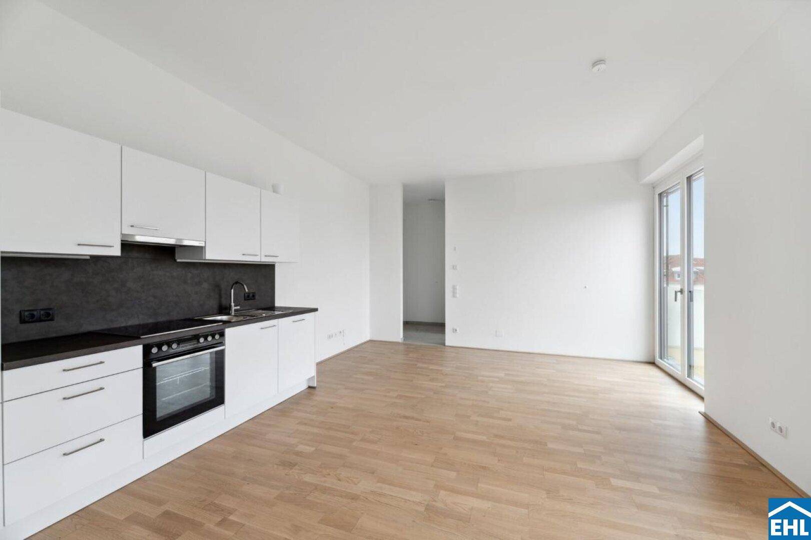 Moderne Küchenzeile in Weiß mit integriertem Backofen und ausreichend Platz für einen Essbereich.