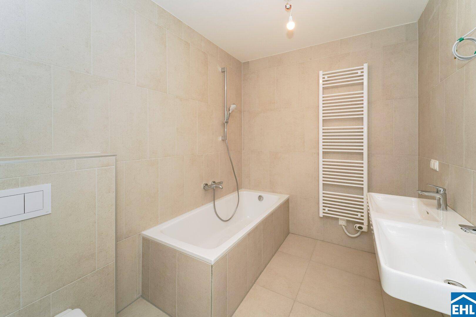Modernes Badezimmer mit Badewanne, Wand-WC und beheiztem Handtuchhalter.