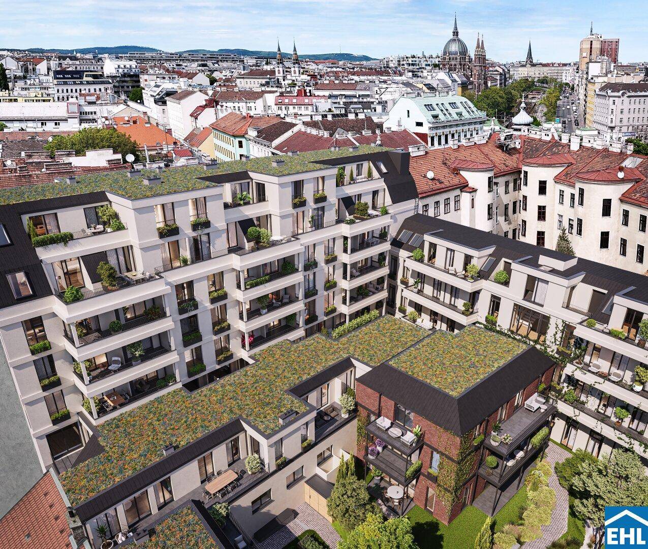 Luftaufnahme des modernen Wohnkomplexes mit begrünten Dächern und Blick auf die Stadt.