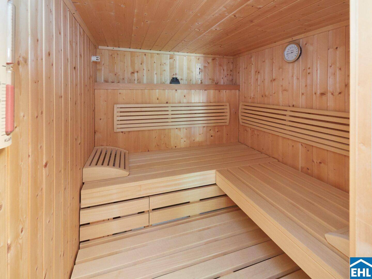 Gemütliche Holzsauna mit Bänken und Temperaturanzeige für entspannende Momente.