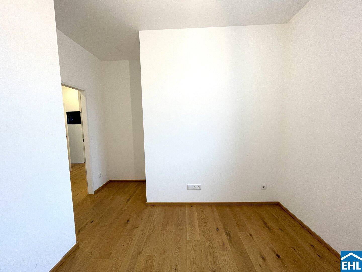 Heller Flur mit Holzboden, der zu weiteren Räumen der Wohnung führt.