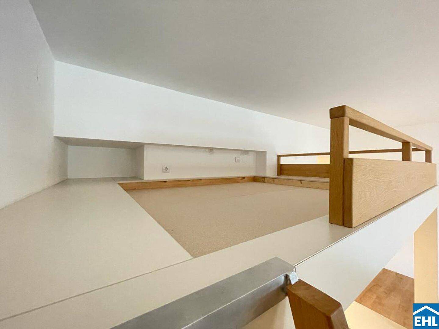 Gemütlicher Schlafbereich im Hochbett mit Holzgeländer und Teppichboden, über eine Leiter erreichbar.