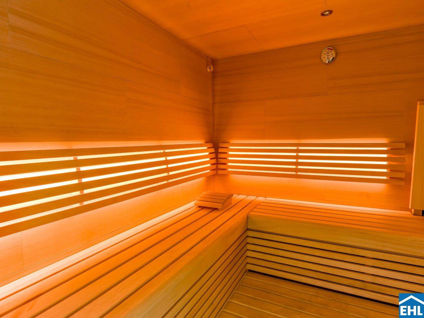 Geräumige Holzsauna mit mehreren Bänken und indirekter Beleuchtung für Entspannung.