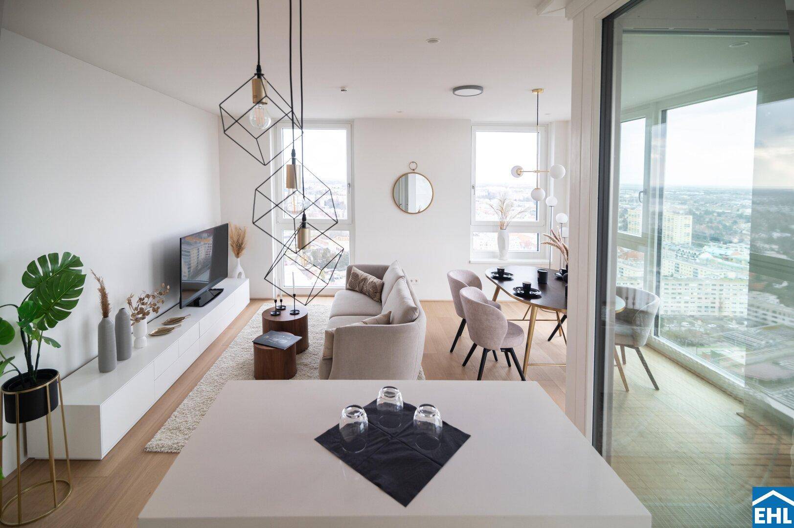 Heller Wohn-Essbereich mit moderner Einrichtung, Stadtblick und Zugang zu einem Balkon.