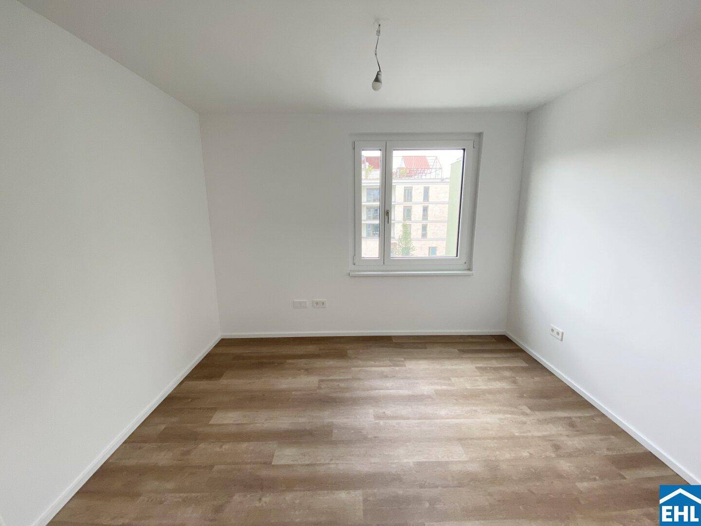 Helles Zimmer mit Laminatboden und Fenster, ideal als Schlaf- oder Kinderzimmer.