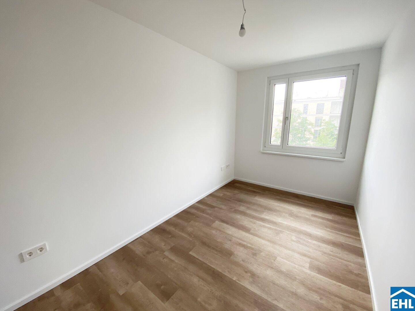 Kleineres Zimmer mit Laminatboden und Fenster, geeignet als Büro oder Gästezimmer.