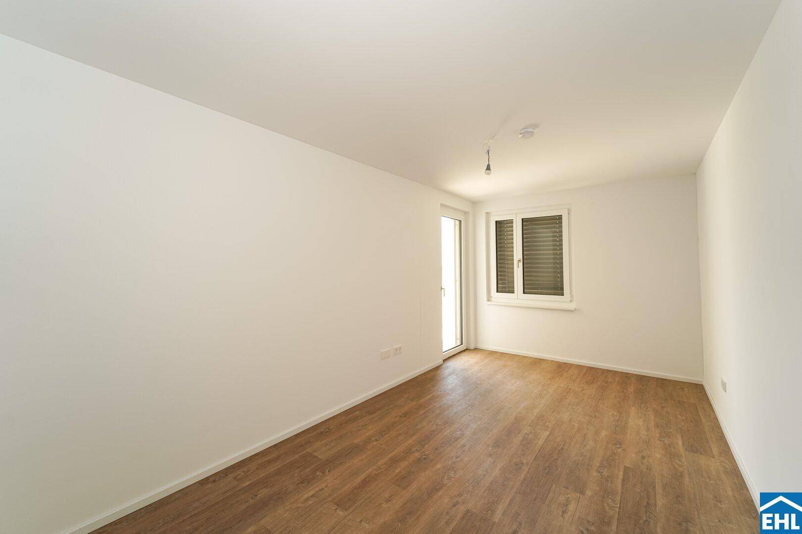 Helles Zimmer mit Laminatboden und Fenster, vielseitig nutzbar als Schlaf- oder Arbeitszimmer.