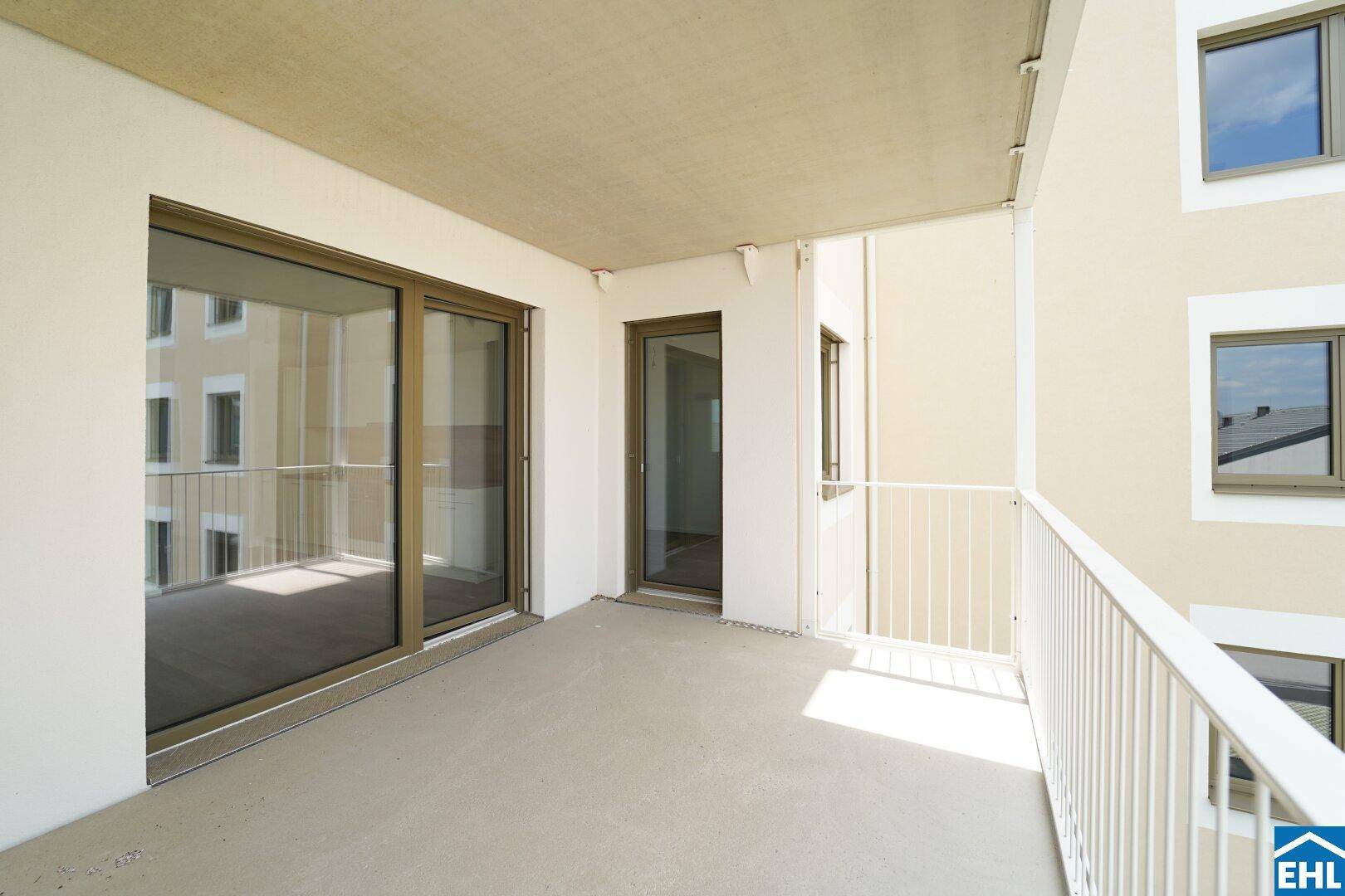 Geräumiger Balkon mit Blick auf die umliegenden Gebäude und viel Sonnenlicht, ideal zum Entspannen.