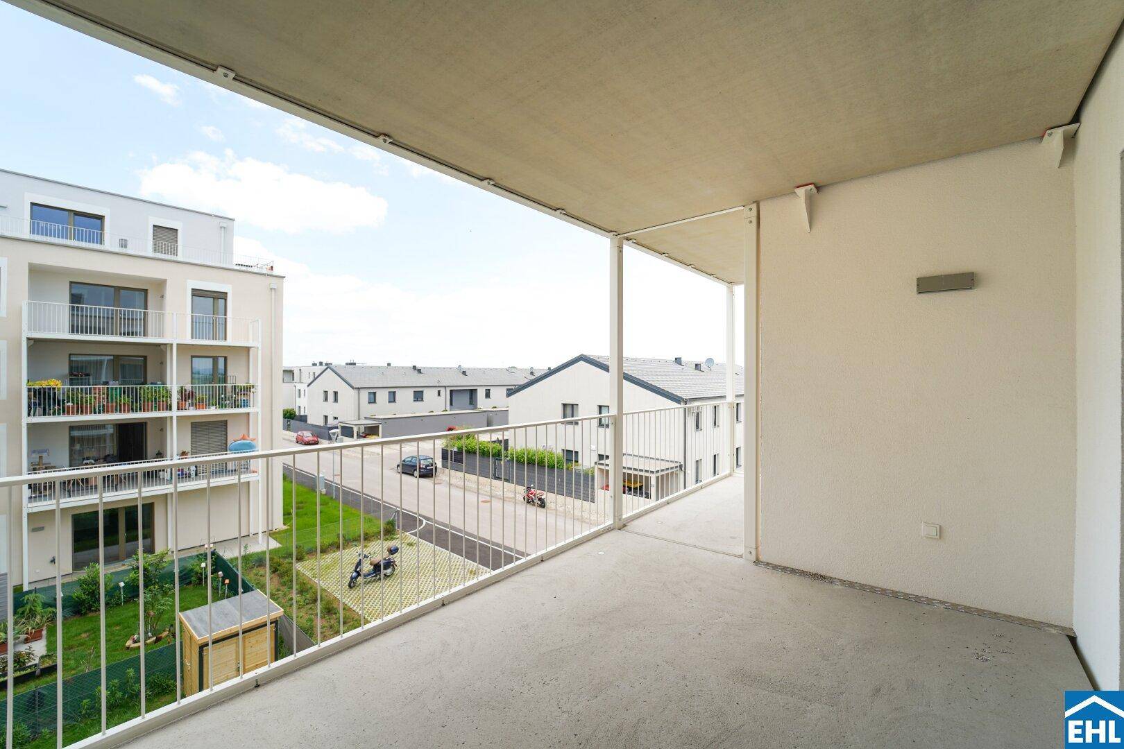 Großer Balkon mit Blick auf die Nachbarschaft und Grünflächen, ideal für entspannte Stunden im Freien.