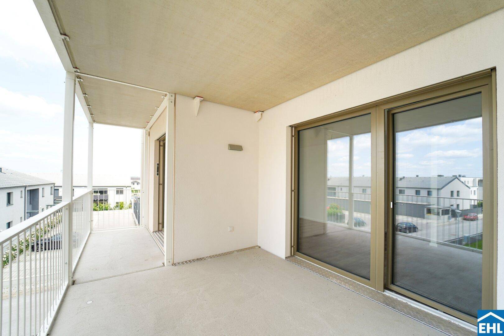 Heller Balkon mit großen Schiebetüren und Blick auf die Umgebung, bietet viel Platz im Freien.