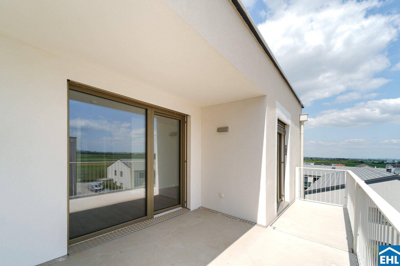 Geräumiger Balkon mit weitem Blick über die Landschaft und den Himmel.