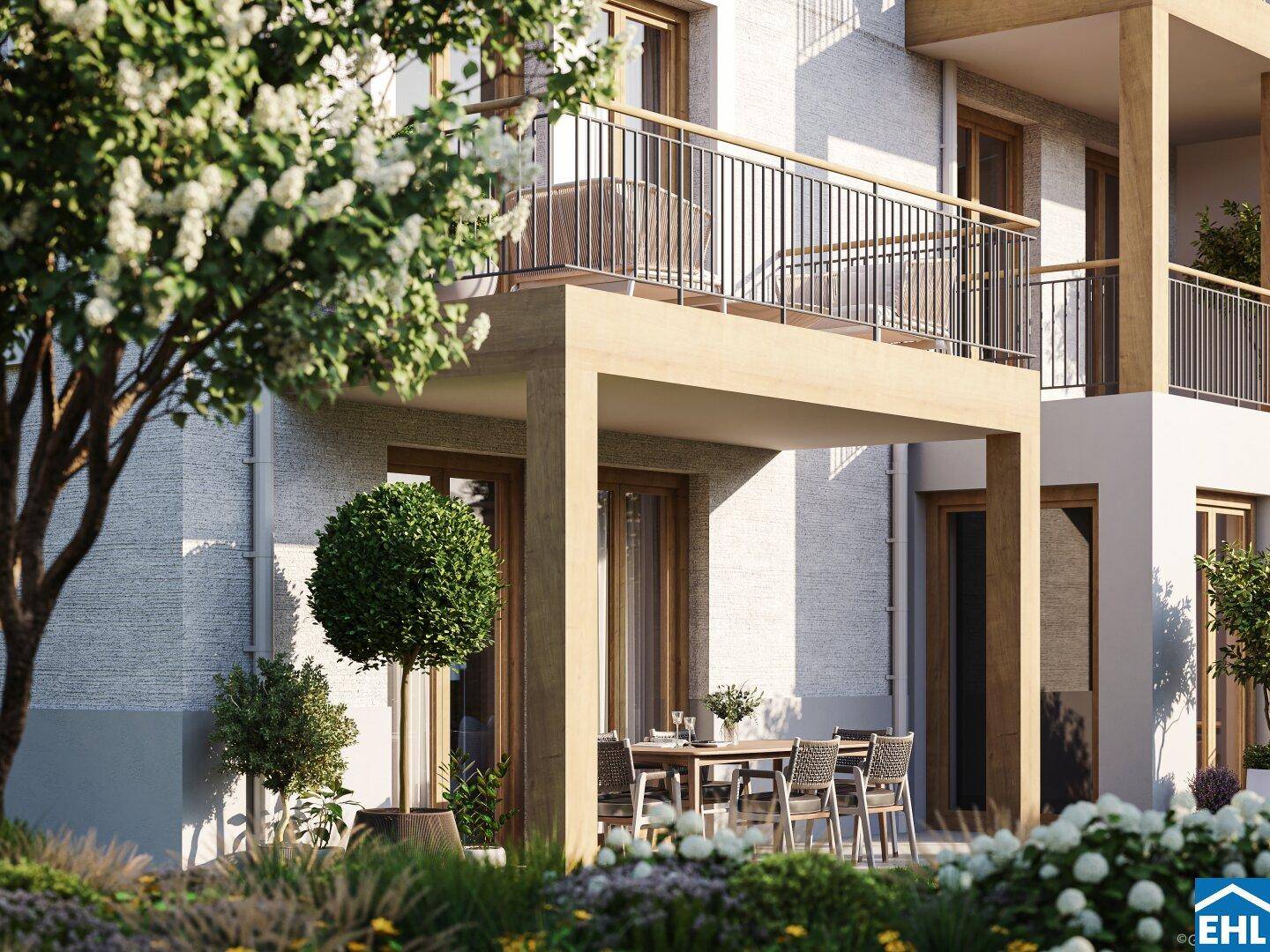 Überdachte Terrasse mit Esstisch und Stühlen, umgeben von blühenden Pflanzen und Grünflächen.