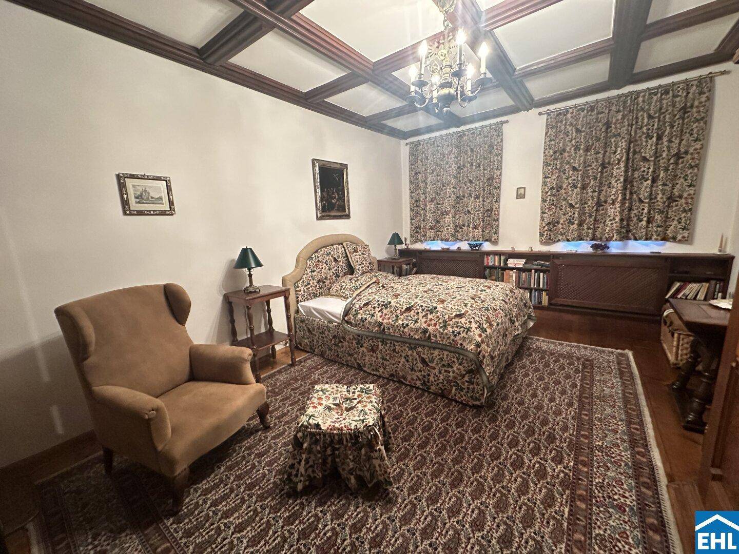 Gemütliches Schlafzimmer mit Holzbalkendecke, Teppichboden und traditionellen Möbeln.