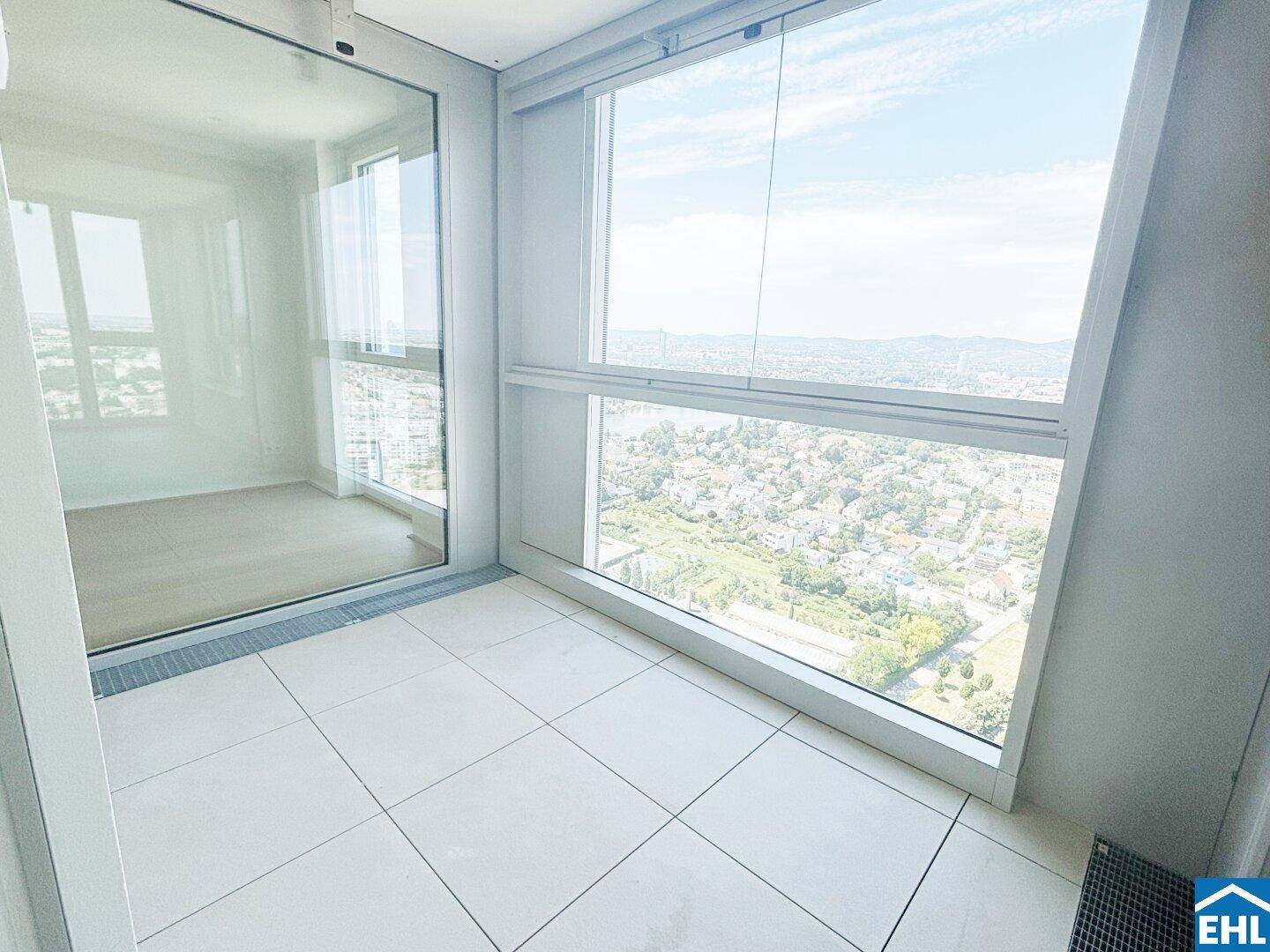 Helle Loggia mit Fliesenboden und Panoramablick über die Stadt und die Umgebung.