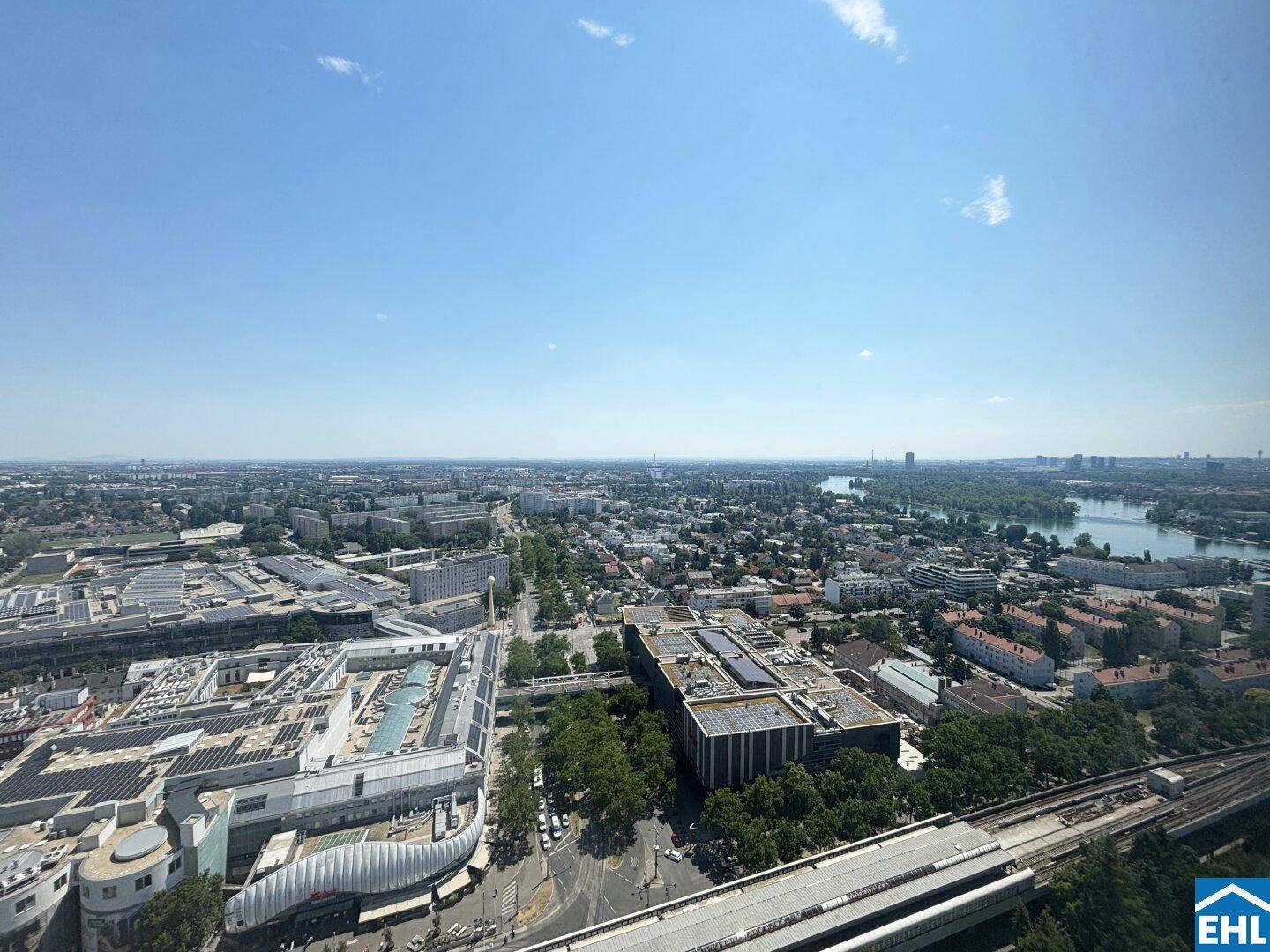 Panoramablick über die Stadt mit Flusslandschaft und weitläufiger Bebauung unter blauem Himmel.