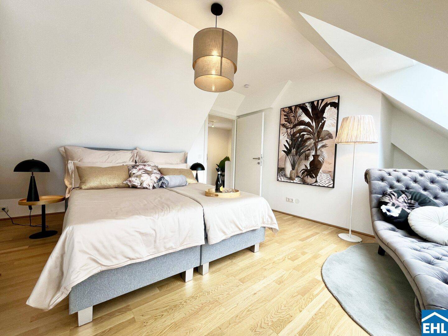 Gemütliches Schlafzimmer mit Holzboden, Dachschrägen und moderner Einrichtung.