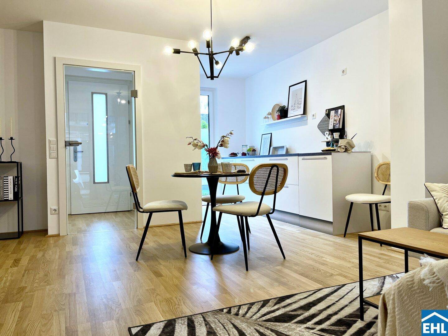 Heller Essbereich mit Holzboden und moderner Pendelleuchte, offen zum Wohnbereich und Flur.