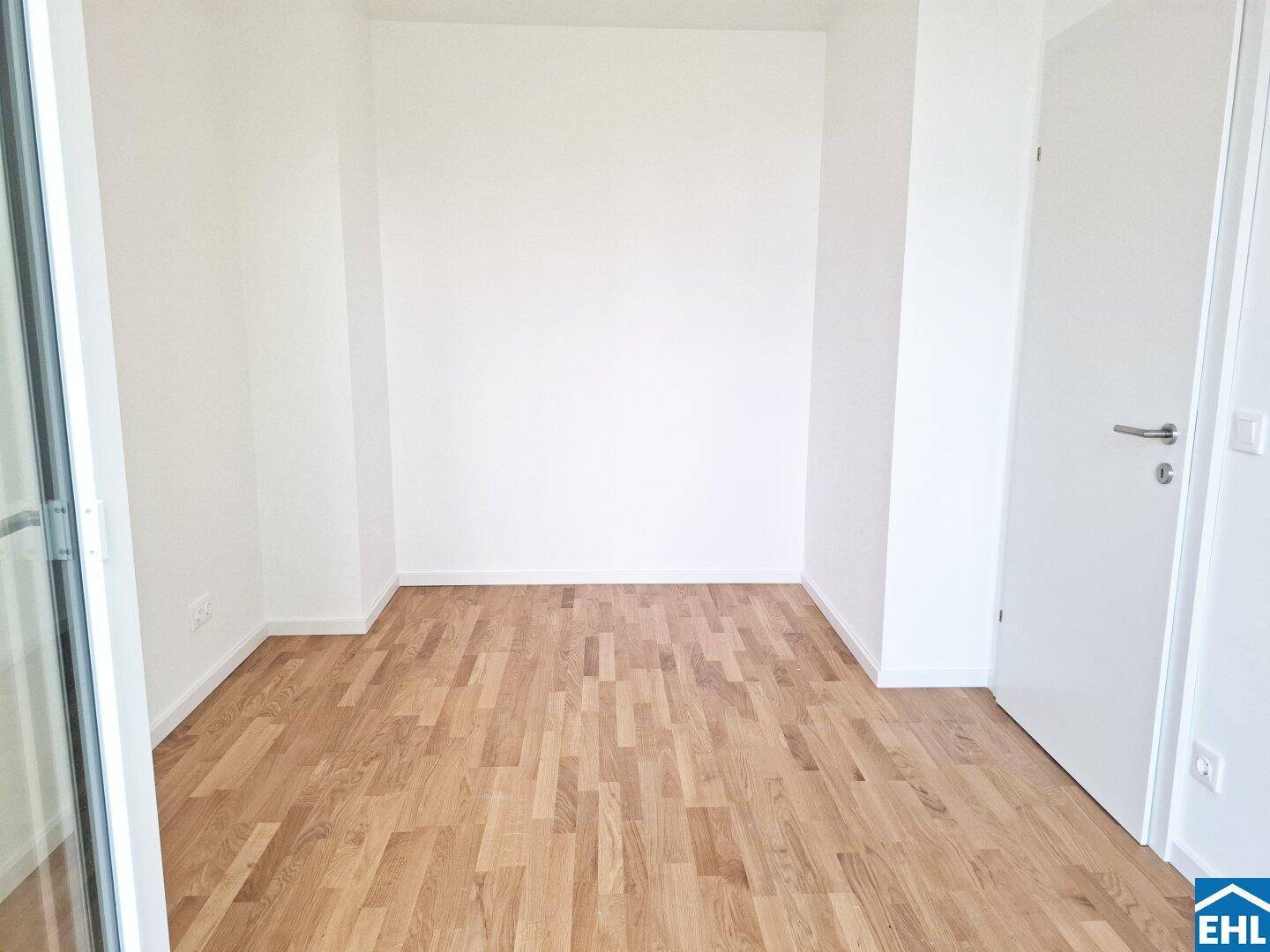 Unmöblierter Raum mit Holzboden und weißen Wänden, bereit zur individuellen Gestaltung.