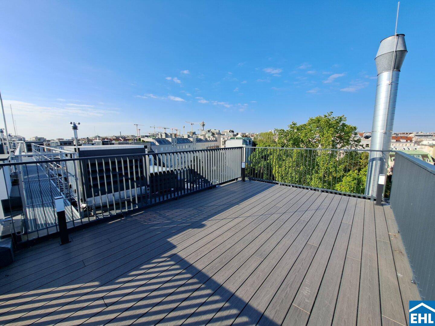 Weitläufige Dachterrasse mit Panoramablick über die Stadt und umliegende Gebäude.